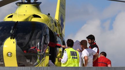 Des sauveteurs prennent soin de Christopher Froome sur le toit du centre hospitalier de Roanne (Loire), le 12 juin 2019. (ANNE-CHRISTINE POUJOULAT / AFP)