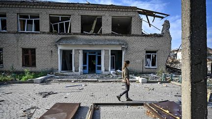 Une femme regarde les ruines d'un hôpital détruit par une bombe russe, le 27 juillet 2024, dans la région de Donetsk, en Ukraine. (DMYTRO SMOLIENKO / NURPHOTO / AFP)