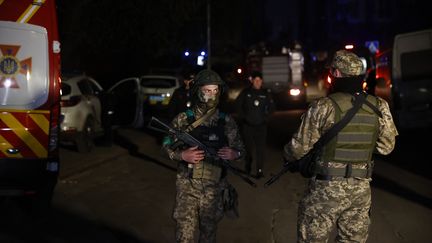 Des militaires devant un immeuble d'habitation détruit à Kiev (Ukraine) après une frappe russe, le 28 avril 2022. (DOGUKAN KESKINKILIC / ANADOLU AGENCY / AFP)