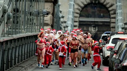 C'est devenu une tradition dans la capitale hongroise: les Père Noël se multiplient à la mi-décembre et courent dans le centre historique dans toutes les tenues, à condition qu'elles soient rouges. Le but: attirer l'attention sur le sort des enfants démunis. (ATTILA KISBENEDEK / AFP)