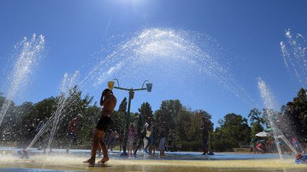 Des enfants se rafra&icirc;chissent sous des jets d'eau, pendant un &eacute;t&eacute; de fortes chaleurs, le 1er ao&ucirc;t 2013 &agrave; Strasbourg (Bas-Rhin). (PATRICK HERTZOG / AFP)