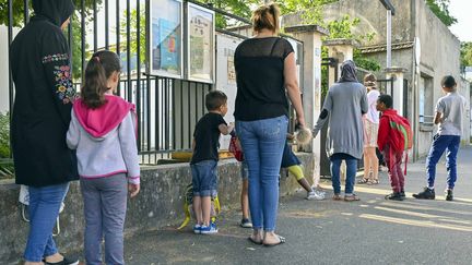 Des parents accompagnent leurs enfants à l'école, le 2 juin 2020, à Villeurbanne (Rhône). (ROLLAND QUADRINI / MAXPPP)