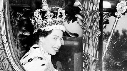 La reine Elisabeth II, dans le carrosse royal, peu de temps après son couronnement à l'abbaye de Westminster, le 2 juin 1953. (STF / INP / AFP)