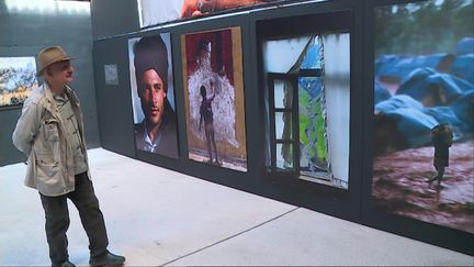 Rez Deghati devant ses photos exposées sur le site le Chameau à Châteauvillain. (M. Meyer / France Télévisions)