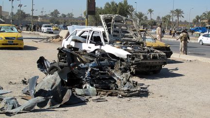 Des carcasses de voitures &agrave; Bagdad (Irak) apr&egrave;s un attentat, le 20 mars 2012. (KHALIL AL-MURSHIDI / AFP)