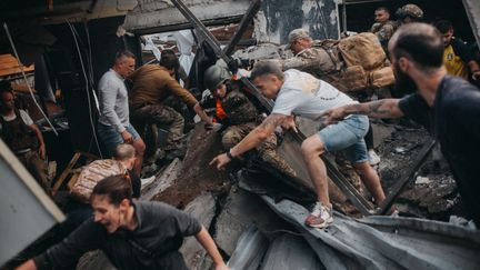 Des habitants tentent de porter secours aux victimes, mardi 27 juin, après une frappe sur un restaurant à Kramatorsk, dans l'est de l'Ukraine. (WOJCIECH GRZEDZINSKI / ANADOLU AGENCY / AFP)