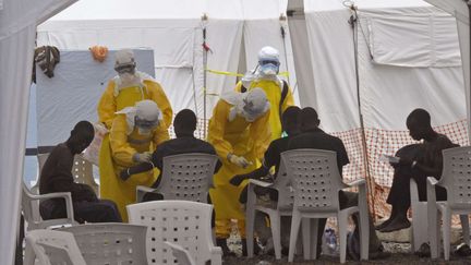 Des m&eacute;decins en combinaison jaune s'occupent de patients, dans un centre de Monrovia, au Liberia, le 8 septembre 2014. (ABBAS DULLEH / AP / SIPA)