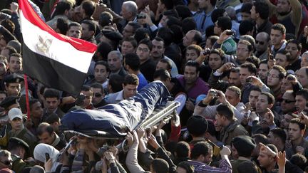 La foule porte la d&eacute;pouille d'un des 14 policiers tu&eacute;s dans l'attentat &agrave; la voiture pi&eacute;g&eacute; de Mansoura (Egypte), le 24 d&eacute;cembre 2013. (MOHAMED ABD EL GHANY / REUTERS)