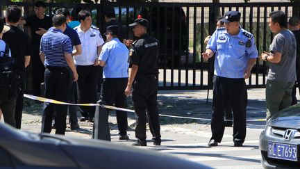 Des personnels de sécurité autour du site où un homme a déclenché une explosion sans faire de blessés, le 26 juillet 2018 devant l'ambassade des Etats-Unis à Pékin (Chine).&nbsp; (JUN YASUKAWA / YOMIURI / AFP)