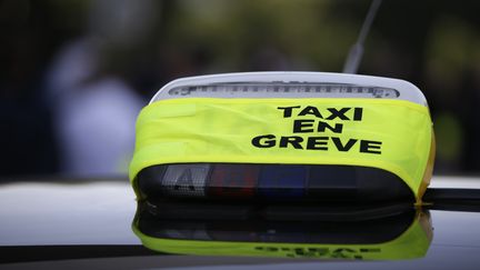 Une enseigne de taxi en gr&egrave;ve au blocus de la Porte Maillot &agrave; Paris le 25 juin 2015. (KENZO TRIBOUILLARD / AFP)