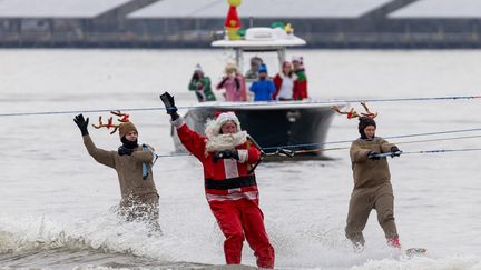 Le père Noël et ses rennes ont troqué le traîneau contre des skis nautiques, à Alexandria, en Virginie (côte est des Etats-Unis), le 24 décembre 2023. (JULIA NIKHINSON / AFP)