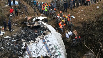 Les secours près de la carlingue de l'avion qui s'est écrasé au Népal, le 16 janvier 2023. (PRAKASH MATHEMA / AFP)