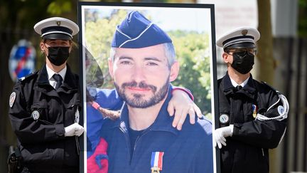 Des policiers portent le portrait d'Eric Masson, agent de police tué en intervention le 5 mai, lors d'une cérémonie d'hommage national, le 11 mai 2021 à Avignon.&nbsp; (NICOLAS TUCAT / POOL / AFP)