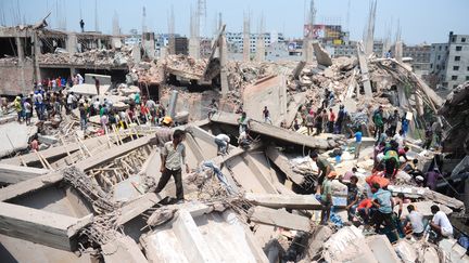 Les volontaires qui cherchent des survivants dans les décombres du Rana Plaza, près de Dacca, au Bangladesh, le 24 avril 2013. (MUNIR UZ ZAMAN / AFP)