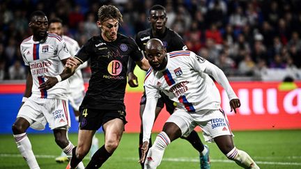 Le Lyonnais Moussa Dembélé (à droite) au duel avec le Toulousain Anthony Rouault (à gauche) lors d'OL-TFC, le 7 octobre 2022. (JEFF PACHOUD / AFP)