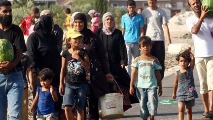 Des réfugiés syriens à proximité du camp de réfugiés de Kilis en Turquie. (ADEM ALTAN / AFP)