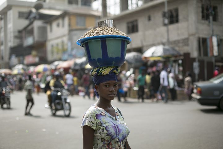 Une femme porte sur la tête un récipient rempli d'arachides à Freetown, capitale de la Sierra Leone, le 16 décembre 2014. (BAZ RATNER / X02483)