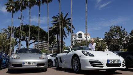 Un visiteur regarde des voitures Porsche, à Cannes le 28 avril 2019. (MAXPPP)