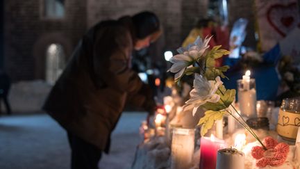 Des passants rendent hommage aux victimes de l'attentat,&nbsp;lundi 30 janvier, dans les rues de Québec. (ALICE CHICHE / AFP)