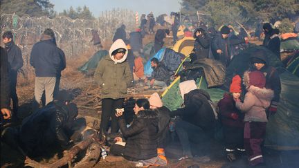 Des&nbsp;migrants massés à la frontière entre la Pologne et la Biélorussie,&nbsp;le 9 novembre 2021. (LEONID SHCHEGLOV / BELTA / AFP)