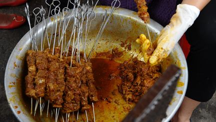 Un commerçant de Hanoï (Vietnam) prépare de la viande de chien,&nbsp;le 26 juillet 2012. (HOANG DINH NAM / AFP)