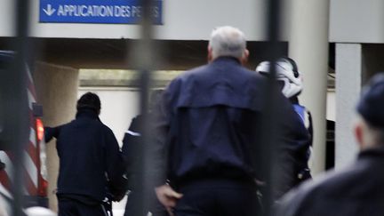 St&eacute;phane Moitoiret (G) arrive escort&eacute; par des policiers, le 5 d&eacute;cembre 2011 au tribunal de Bourg-en-Bresse pour le premier jour de son proc&egrave;s en premi&egrave;re instance. (JEAN-PHILIPPE KSIAZEK / AFP)