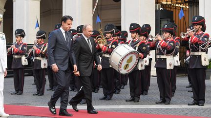 Le Premier ministre italien Giuseppe Conte (à gauche) et le président russe Vladimir Poutine (à droite) passent en revue un régiment militaire à leur arrivée au Palazzo Chigi, à Rome, le 4 juillet 2019. (TIZIANA FABI / AFP)