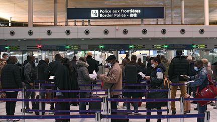 Des passagers attendent pour présenter leurs documents d'identité et leur attestation à la police aux frontières de l'aéroport de Roissy Charles-de-Gaulle, le 1er février 2021. (CHRISTOPHE ARCHAMBAULT / AFP)