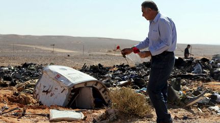 &nbsp; (Un homme dépose des fleurs sur le lieu du crash d'un avion russe en Egypte © REUTERS/Mohamed Abd El Ghany)