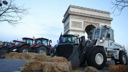 La Coordination rurale a mené une action surprise et dans le calme autour de l'Arc de Triomphe, bloquant le haut des Champs-Elysées à Paris avec des bottes de paille et des tracteurs, le 1er mars 2024. (THOMAS SAMSON / AFP)