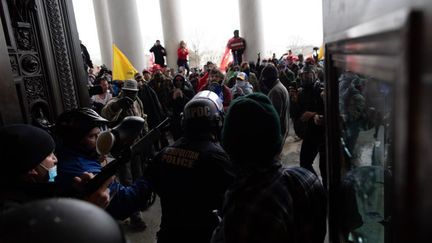 La police intervient pour évacuer des partisans de Donald Trump qui ont fait irruption au Capitole, à Washington (Etats-Unis), le 6 janvier 2021. (MOSTAFA BASSIM / ANADOLU AGENCY / AFP)