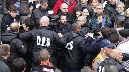 Une &eacute;quipe de l'&eacute;mission du "Petit Journal" de Canal+, prise &agrave; partie par des militants du FN &agrave; Paris, le 1er mai 2015. (THOMAS SAMSON / AFP)