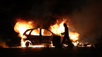 Une voiture incendiée au Port, le 30 juin 2023 sur l'île de La Réunion. (RICHARD BOUHET / AFP)