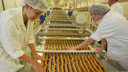 Des employés sur une chaine de production de biscuits, à Quimper, le 26 juin 2002 (illustration). (MARCEL MOCHET / AFP)