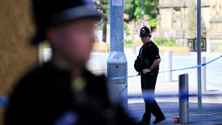 Des policiers britanniques gardent la zone qui entoure la Manchester Arena, le 23 mai 2017, au lendemain d'un attentat dans cette salle de concert. (JON SUPER / AFP)