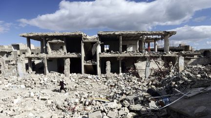 Une femme marche sur les d&eacute;combres du quartier de la Douma, &agrave; Damas, le 4 mars 2015. (BASSAM KHABIEH / REUTERS)