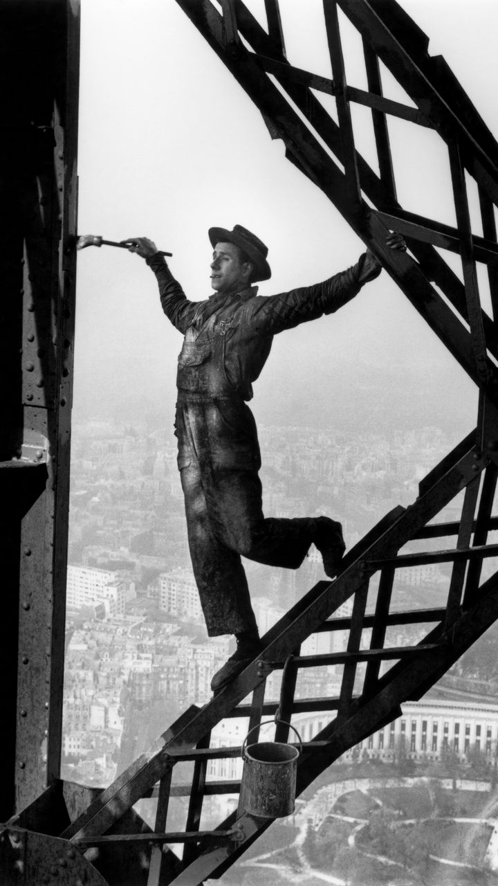 "Le Peintre de la tour Eiffel". Lorsque Marc Riboud s’installe à Paris en 1953, la tour Eiffel est en train d’être repeinte. Il grimpe par l’escalier à la rencontre de ces peintres acrobates, muni de son appareil. (© Marc Riboud / Fonds Marc Riboud au MNAAG)