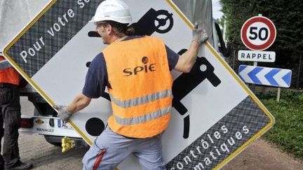 démontage de panneau avertissant de la présence d'un radar, le 16 mai 2011 à Dijon (AFP PHOTO / JEFF PACHOUD)