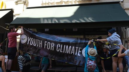 Des membres de "Youth for Climate France"accroche l'une de leurs banderoles sur un restaurant McDonald's de Bordeaux, en juillet 2019. (MEHDI FEDOUACH / AFP)