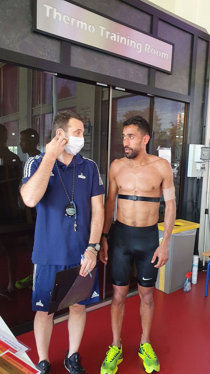 Franck Brocherie (G), chercheur au laboratoire sport, expertise et performance de l'INSEP avec l'athlète Morhad Amdouni (D) devant la salle d'entraînement thermique, le 4 juillet 2021. (BORIS HALLIER / RADIO FRANCE)