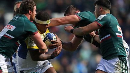 La puissance du centre de Clermont Apisai Naqalevu bien maîtrisée par la défense des Anglais de Leicester en Champions Cup, le 17 décembre 2022. (GEOFF CADDICK / AFP)