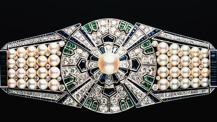 Clip ‘Yaguruma’, Mikimoto, Japon, 1937, en platinum, or 18 carats, perles Akoya, diamants, saphirs et émeraudes
 (Mikimoto Pearl Island, Japan)