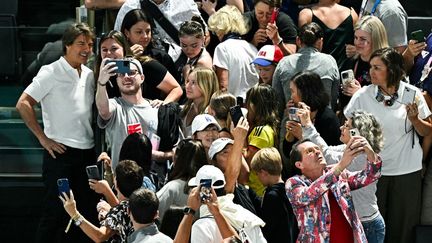 Il vole la vedette aux sportifs, l'acteur américain Tom Cruise prend des selfies avec des fans alors qu'il assiste à la qualification de la gymnastique artistique féminine lors des Jeux olympiques de Paris 2024 à l'arène de Bercy. (GABRIEL BOUYS / AFP)