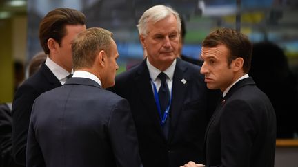 Le président du Conseil européen Donald Tusk (de dos) discute avec le négociateur de l'UE, Michel Barnier, et le président français, Emmanuel Macron, le 25 novembre 2018, à Bruxelles (Belgique). (JOHN THYS / AFP)