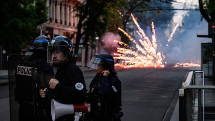 Des policiers confrontés à des tirs de mortier d'artifice, à Lyon, le 30 juin 2023. (JEFF PACHOUD / AFP)