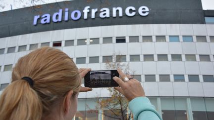 Une femme en train de prendre en photo Radio France, avec son smartphone.&nbsp; (JEAN-CHRISTOPHE BOURDILLAT / RADIO FRANCE)