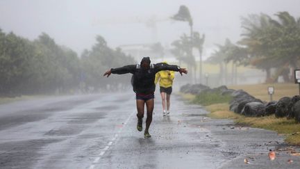 Un homme affronte les vents violents de Bejisa, &agrave; La R&eacute;union, le 2 janvier 2014. (RICHARD BOUHET / AFP)