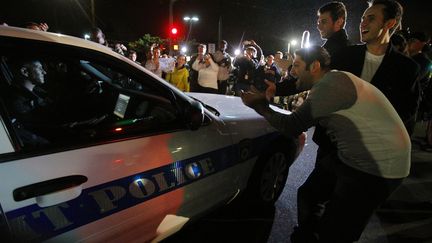 D'autres ont fait une haie d'honneur aux v&eacute;hicules de police et de pompiers qui s'&eacute;loignaient. (BRIAN SNYDER / REUTERS)