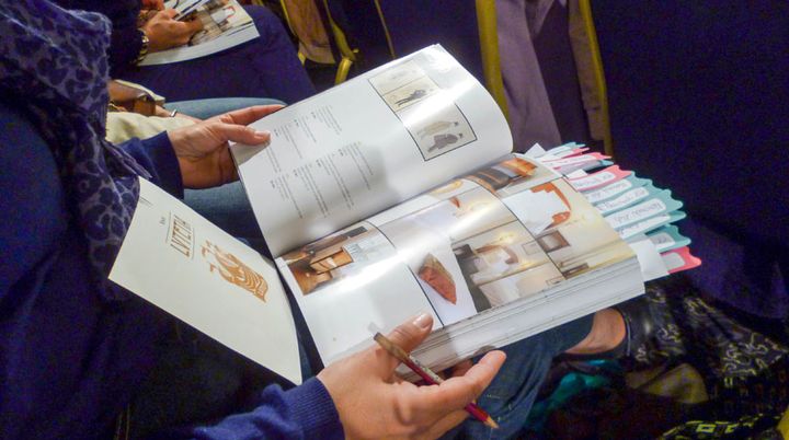 Sur le catalogue de la vente, Christine a marqu&eacute; les objets qui l'int&eacute;ressent, mercredi 21 mai 2014, au Lutetia, &agrave; Paris. Elle a jet&eacute; son d&eacute;volu sur une paire d'appliques Art d&eacute;co. (JEROMINE SANTO GAMMAIRE / FRANCETV INFO )