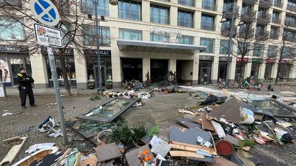 Des débris gisent devant l'hôtel Radisson Blu, où l'énorme aquarium situé dans le hall de l'hôtel a éclaté, le 16 décembre 2022, à Berlin (Allemagne). (CUNEYT KARADAG / ANADOLU AGENCY / AFP)